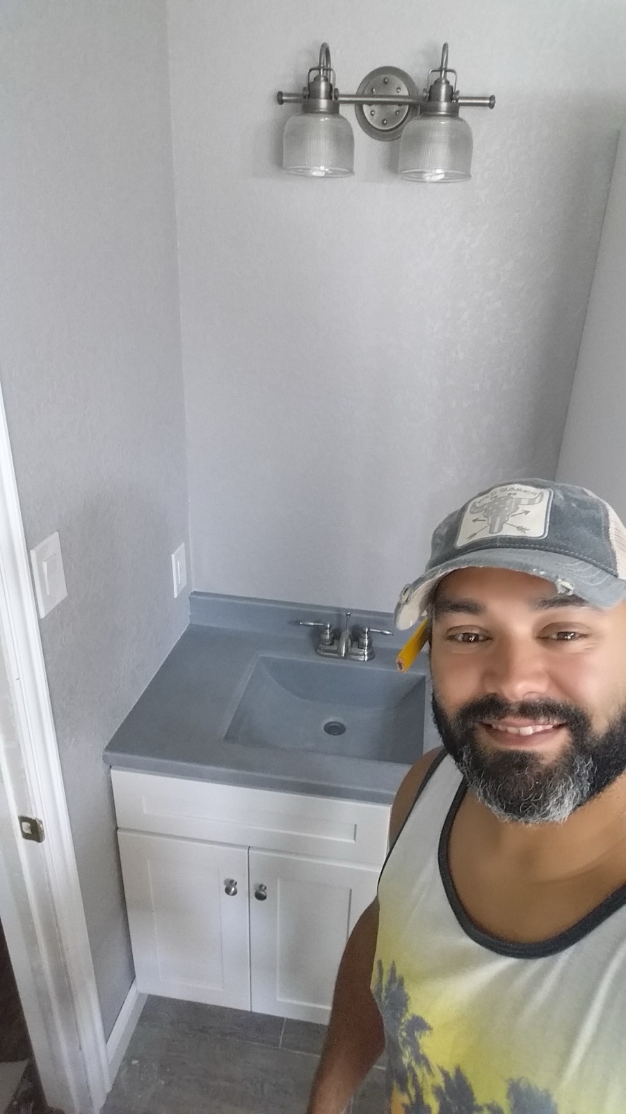 Juan Martinez of MLA Contracting beside a finished bathroom vanity
