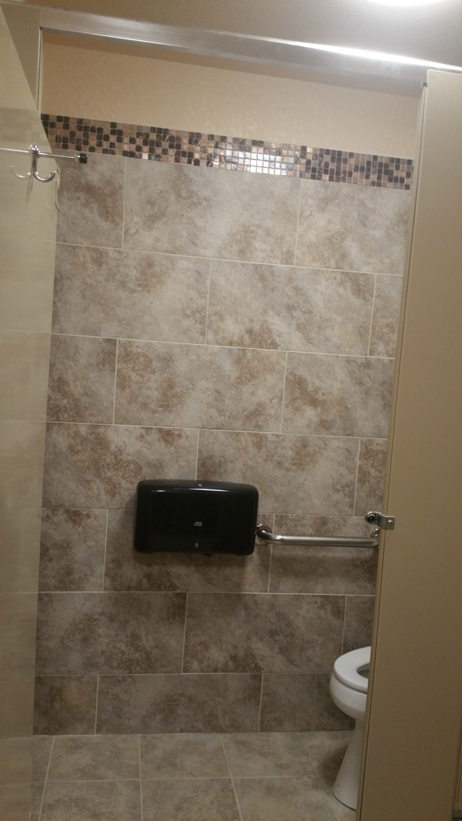 Commercial restroom with tile and an ADA grab bar