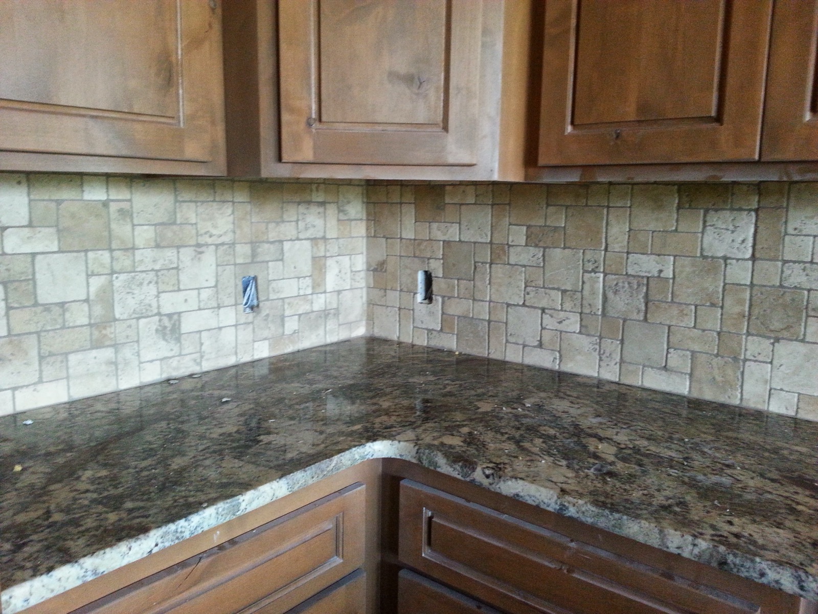 Kitchen with a travertine backsplash and granite counters