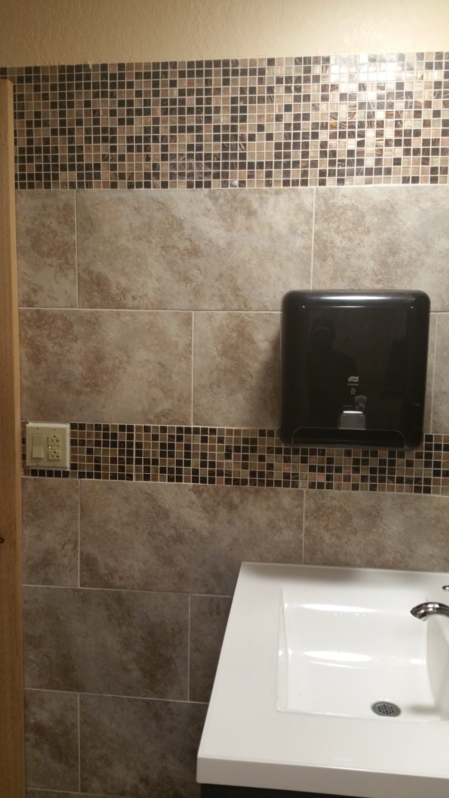 Commercial restroom with tile walls and sink