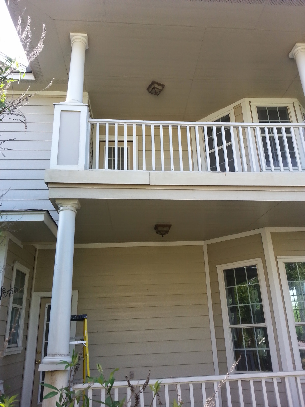 Two-story porch with freshly painted columns and railings